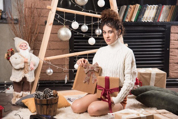 Una mujer feliz sosteniendo cajas de regalo con lazo