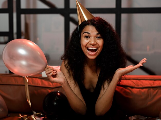 Mujer feliz sosteniendo un globo en una fiesta de fin de año