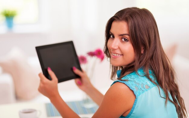 Mujer feliz sosteniendo en la mano tableta digital