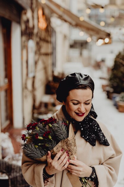 Mujer feliz sosteniendo un ramo de flores en el invierno