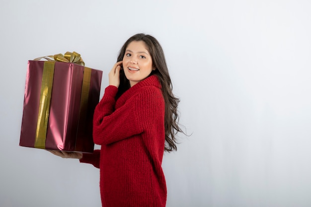 Mujer feliz sosteniendo un regalo de Navidad con cinta.