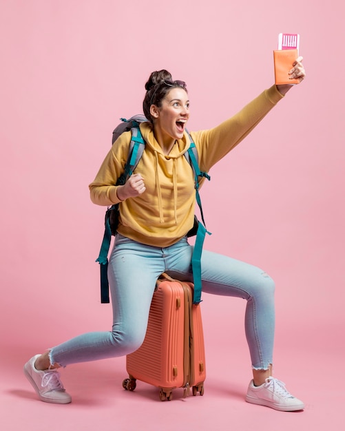 Mujer feliz sosteniendo su pasaporte y boletos de avión