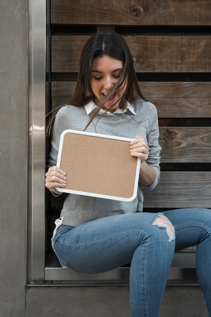 Mujer feliz con tableta de madera