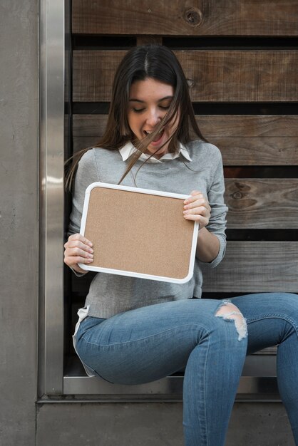 Mujer feliz con tableta de madera