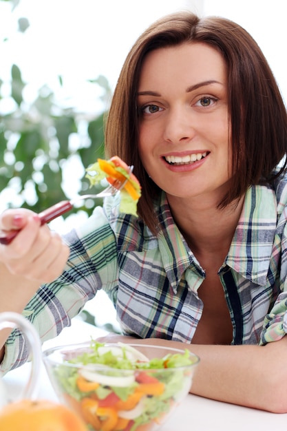 Foto gratuita mujer feliz con tazón de ensalada fresca