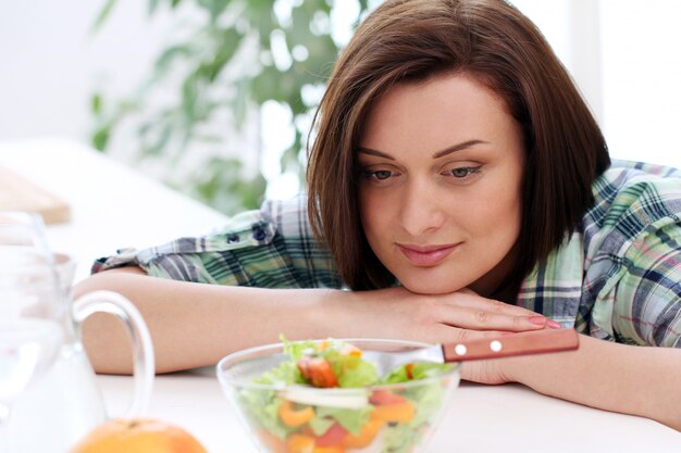 Mujer feliz con tazón de ensalada fresca