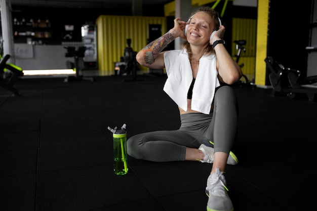 Mujer feliz de tiro completo en el gimnasio