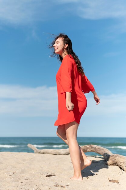 Mujer feliz de tiro completo en la playa