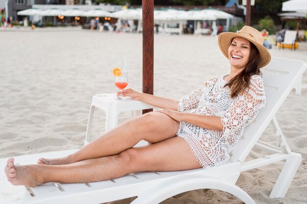 Mujer feliz de tiro completo tendido en hamaca