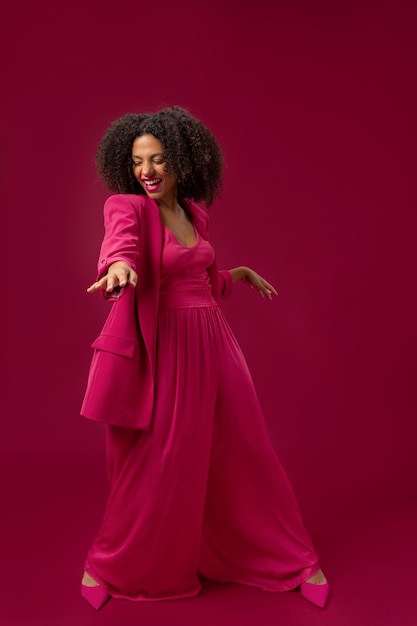 Mujer feliz de tiro completo con traje rosa