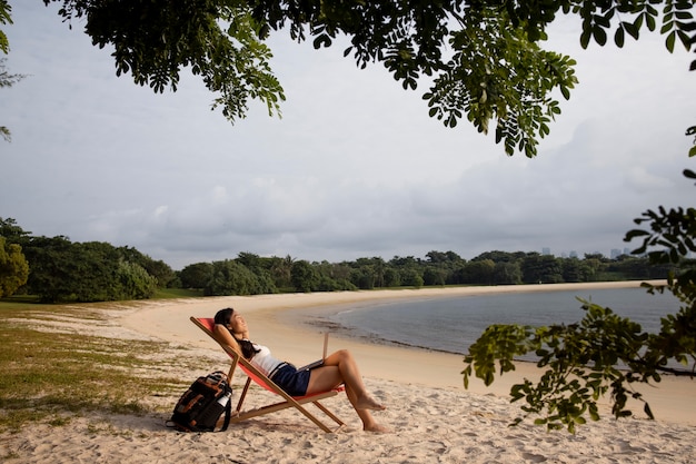 Foto gratuita mujer feliz de tiro largo en la playa