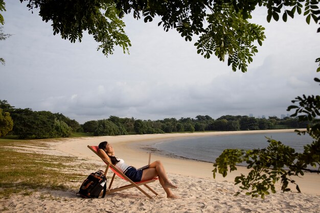 Mujer feliz de tiro largo en la playa