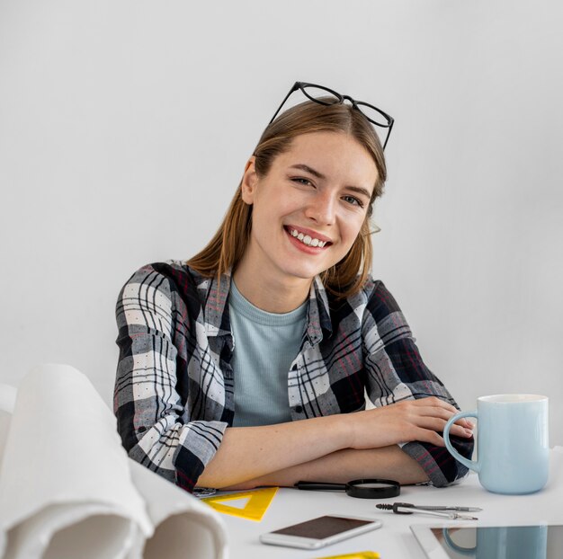 Mujer feliz de tiro medio en el escritorio