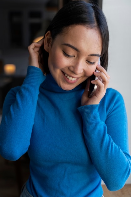 Mujer feliz de tiro medio hablando por teléfono