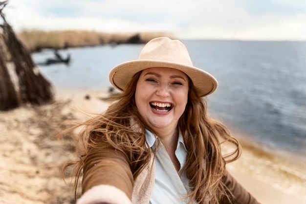 Mujer feliz de tiro medio en la playa