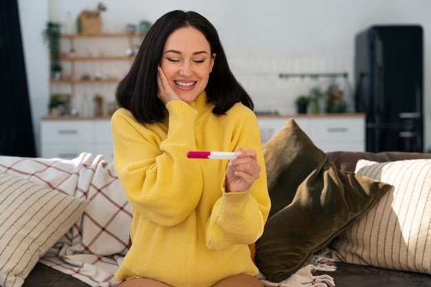 Foto gratuita mujer feliz de tiro medio con prueba de embarazo