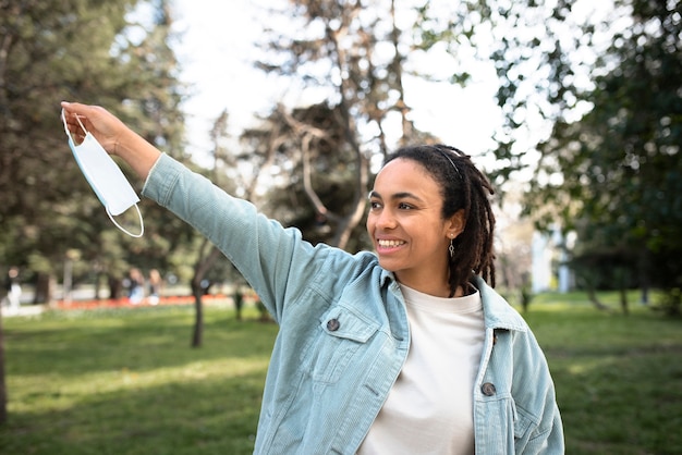 Foto gratuita mujer feliz de tiro medio quitándose la máscara