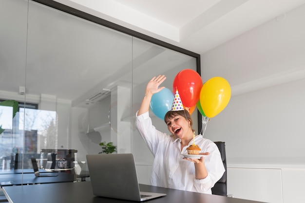 Mujer feliz de tiro medio sosteniendo globos