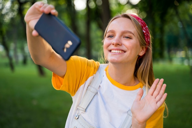 Mujer feliz tomando selfie al aire libre