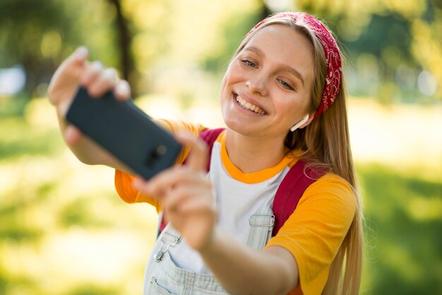 Mujer feliz tomando selfie al aire libre