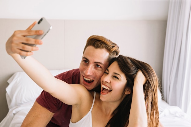 Mujer feliz tomando selfie con hombre