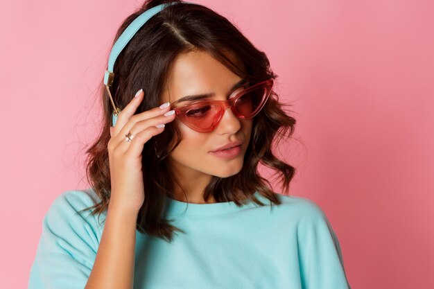 Mujer feliz en traje azul escuchando música por auriculares.