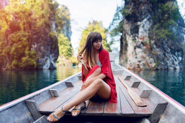 Mujer feliz viaje explorando la naturaleza salvaje del parque nacional de Khao Sok. Sentado en un bote de cola larga de madera sobre acantilados de piedra caliza tropical. Laguna de la isla.