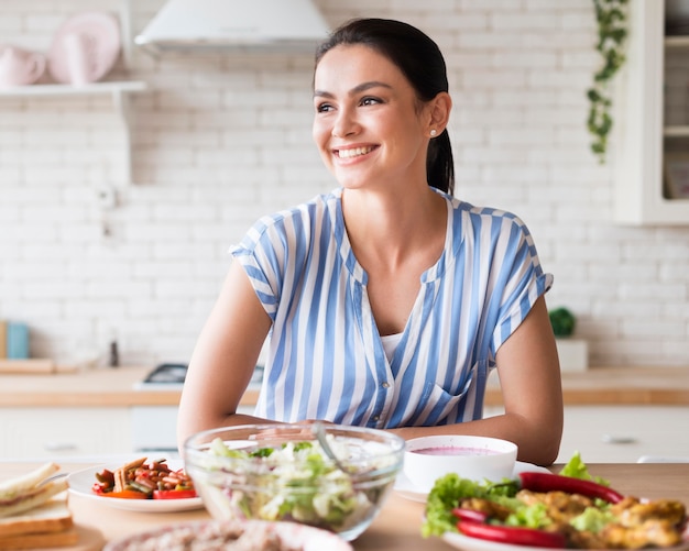 Foto gratuita mujer feliz en vista frontal de la cocina