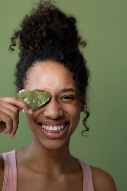 Foto gratuita mujer feliz con vista frontal de gua sha