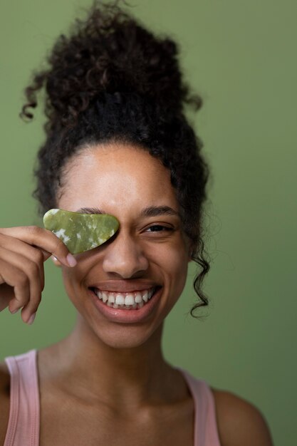 Mujer feliz con vista frontal de gua sha