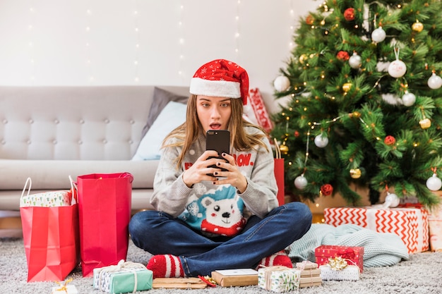 Mujer festiva asombrada con smartphone