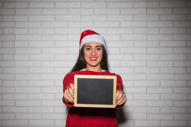 Mujer festiva sonriente con pizarra