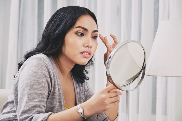 Mujer filipina que ajusta maquillaje