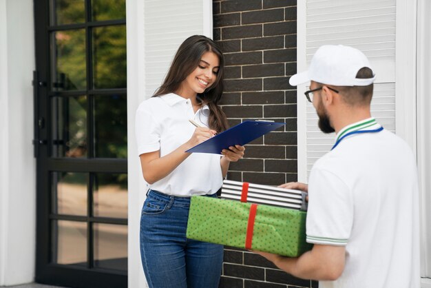 Foto gratuita mujer firmando papel y recibiendo cajas