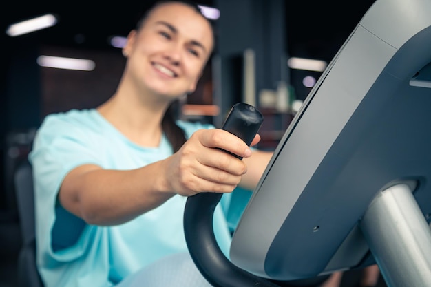 Foto gratuita mujer de fitness en bicicleta haciendo ejercicios de cardio en el gimnasio