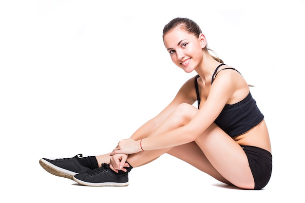 Mujer fitness haciendo ejercicio de estiramiento aislado sobre fondo blanco.