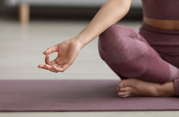 Mujer fitness haciendo yoga en una estera de yoga en casa