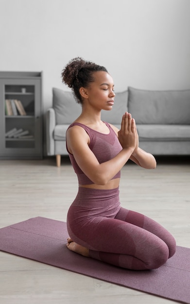 Foto gratuita mujer fitness haciendo yoga en una estera de yoga en casa