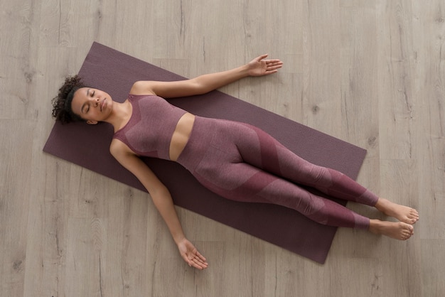 Foto gratuita mujer fitness haciendo yoga en una estera de yoga en casa