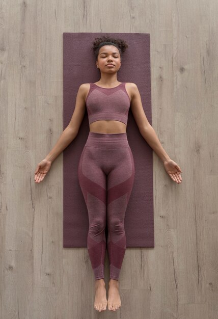 Mujer fitness haciendo yoga en una estera de yoga en casa