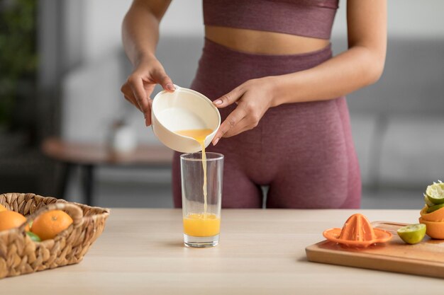 Mujer fitness preparando un jugo de fruta saludable