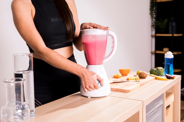 Mujer fitness preparando un zumo desintoxicante