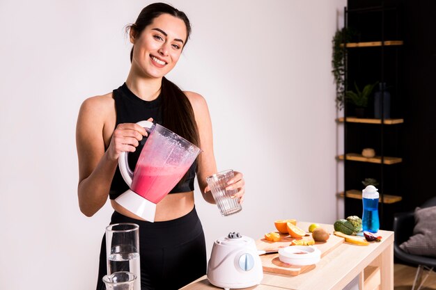 Mujer fitness preparando un zumo desintoxicante