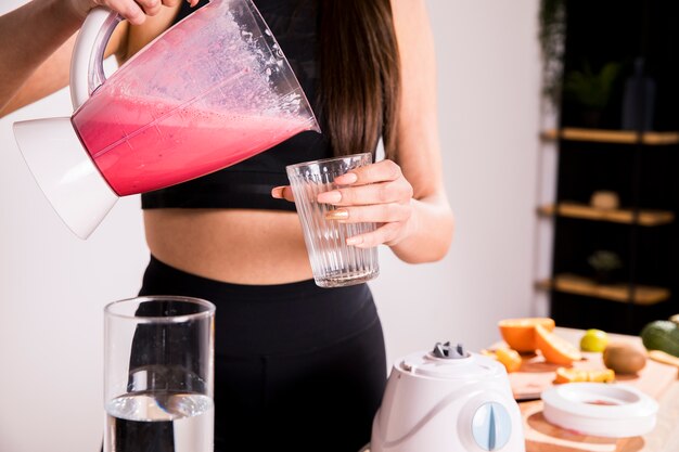 Mujer fitness preparando un zumo desintoxicante