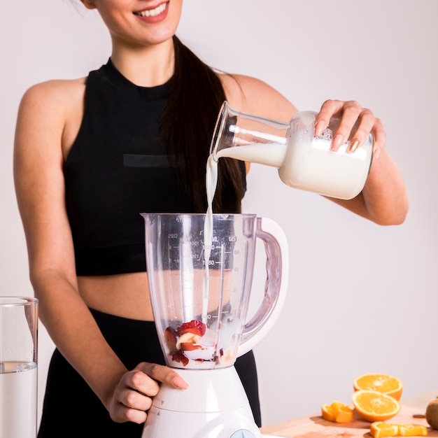 Mujer fitness preparando un zumo desintoxicante