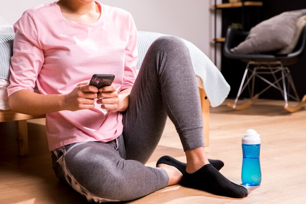 Mujer fitness usando el teléfono móvil