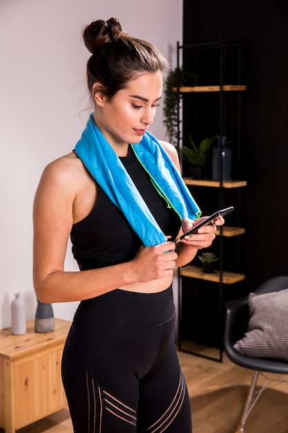 Mujer fitness usando el teléfono móvil