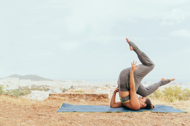 Mujer flexible con pose difícil de yoga