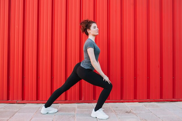 Mujer flexionando los músculos en la calle