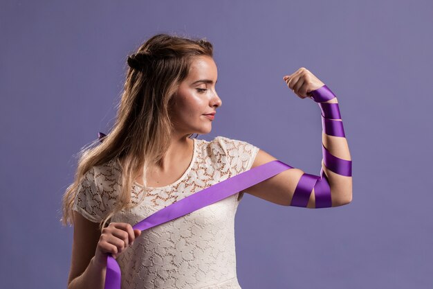 Mujer flexionando su brazo con cinta como un signo de empoderamiento